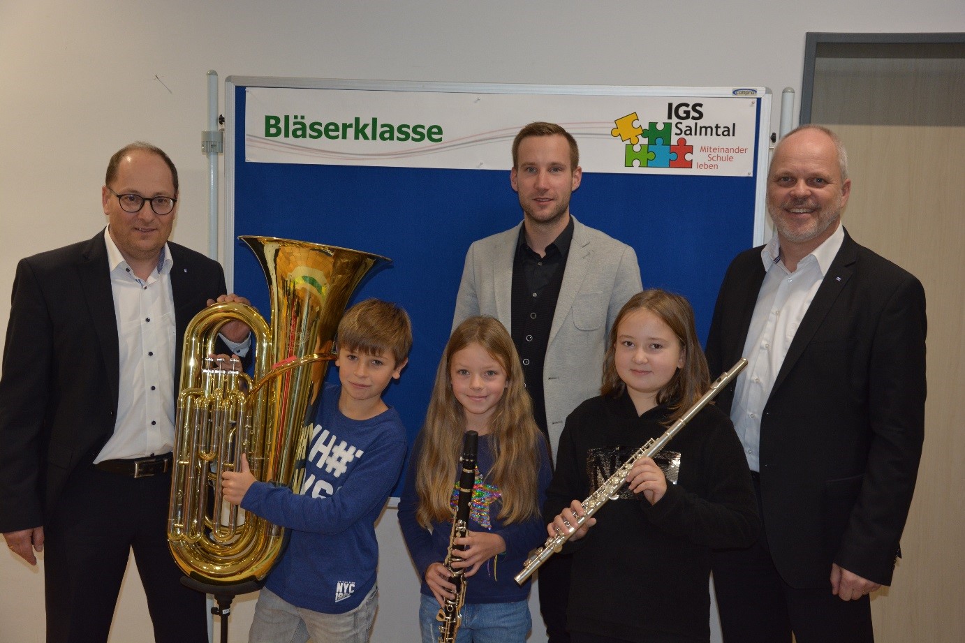 Neben der Crowdfunding-Aktion spendete die VR-Stiftung drei Instrumente (v.l.n.r. Tuba, Klarinette, Querflö-te) im Gesamtwert von 4.500 €. Herr Born, Leiter der Bläserklasse (Mitte), freut sich, dass Herr Michael Hoeck (links) und Gerhard Knauf (rechts),